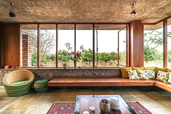 Chiếc ghế dài hình chữ L tại phòng khách, ghế treo và một số loại ghế nhỏ lẻ hơn được sắp xếp ở khu vực xung quanh, tạo cảm giác tiện nghi. Ảnh: Ricken Desai