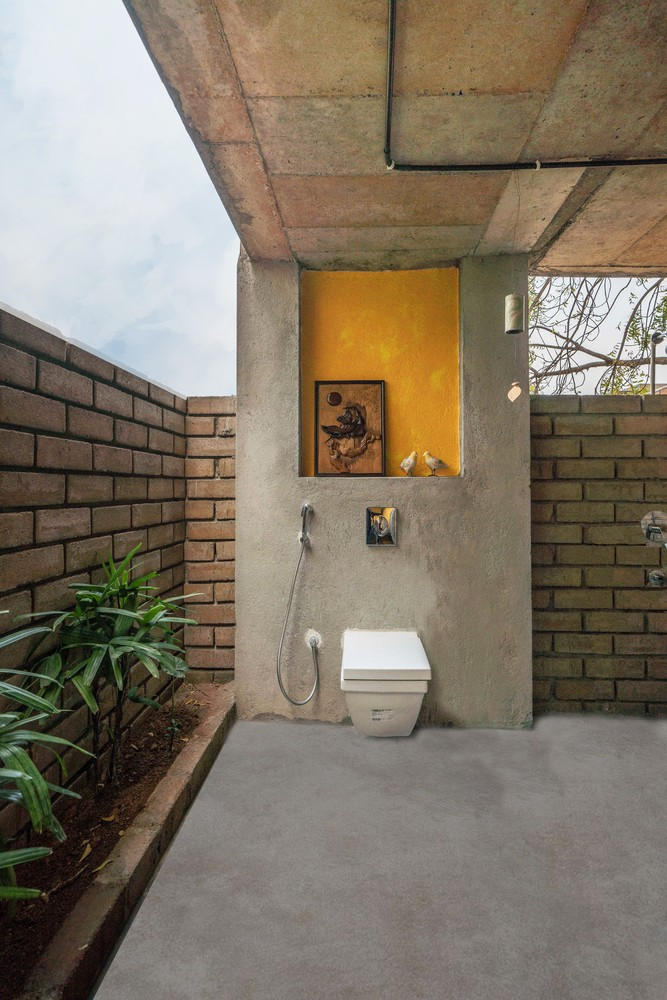 Công trình phụ cũng được xây dựng theo phong cách mở cùng tường gạch trần, sàn được láng mịn, không lát gạch để thuận tiện cho sinh hoạt hàng ngày. Ảnh: Ricken Desai &gt;&gt;&gt; Mời độc giả xem video: Nhà 25m2 - cơ hội cho nhiều người. Nguồn: VTV24