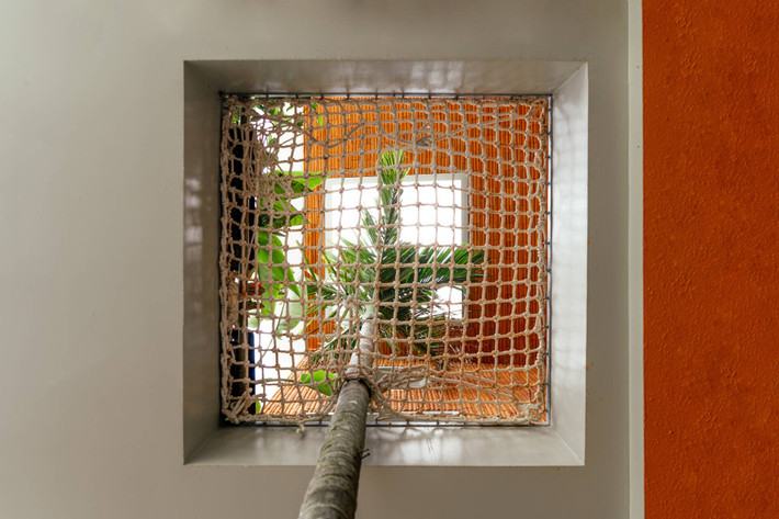 Dưới cây cau, một tấm lưới lớn được bố trí để trẻ em có thể leo trèo, đọc sách, hay đơn giản là nằm thư giãn. Ảnh: Phan Trọng Tín - Minh Anh