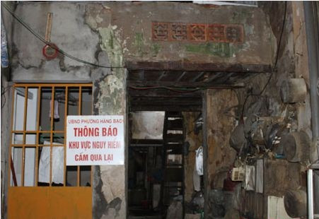 "Khu vực nguy hiểm, cấm qua lại" là tấm biển cảnh báo của UBND phường Hàng Bạc khi mái ngói trên tầng hai của ngôi nhà đã bị sập cả một khoảng lớn. Phường, quận xuống ghi biên bản, rồi gắn tấm biển đó để cảnh báo nguy hiểm cho người dân. Lối lên gác cũng bị khóa trái lại, không cho ai ở vì mái nhà có thể sập bất kỳ lúc nào.