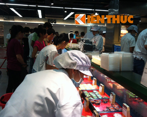 Nhân viên luôn tay tiếp thức ăn tại quầy đồ ăn chín.