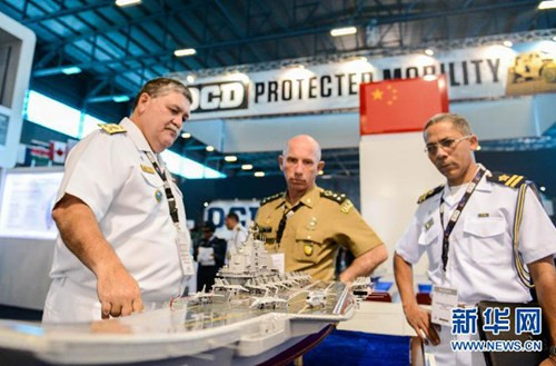 Trung Quốc tham dự triển lãm lần này có 7 doanh nghiệp quốc phòng với nhiều mô hình vũ khí trang bị như máy bay chiến đấu, tàu sân bay, tên lửa, máy bay không người lái. Trong ảnh là quan chức Brazil quan sát mô hình tàu sân bay Liêu Ninh.