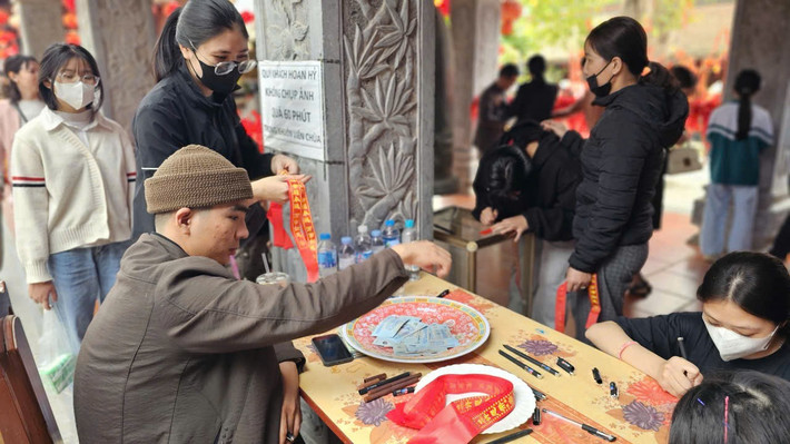 Du khách đặt lễ 20.000 đồng để nhận dải nguyện ước.