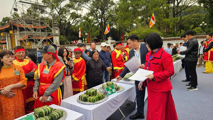 Ban tổ chức chấm điểm phần thi gói bánh chưng.