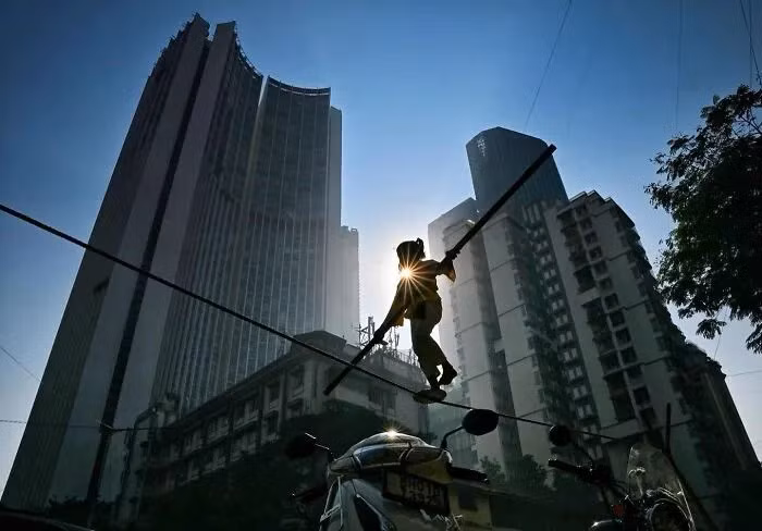Một nghệ sĩ đường phố nhỏ tuổi đi trên dây thăng bằng tại khu Worli, Parel, Mumbai.