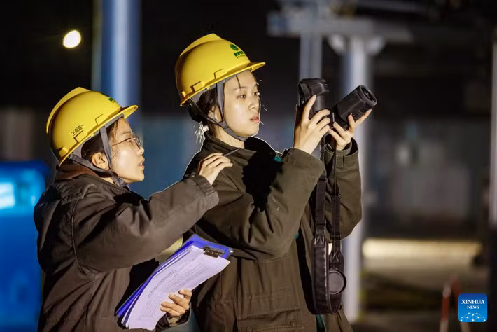 Các nhân viên của một công ty cung cấp điện kiểm tra thiết bị vào ban đêm tại một trạm biến áp ở thành phố Thương Khâu, tỉnh Hà Nam, ngày 10/12. Ảnh: Xinhua News.