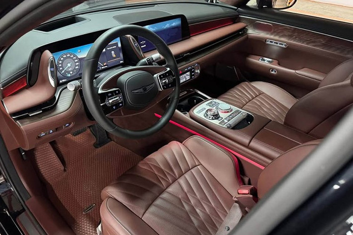 Bước vào cabin, Genesis G90 mang đến không gian sang trọng với ghế da Nappa, ốp gỗ tự nhiên, bảng điều khiển trung tâm 12,3 inch và màn hình HUD. Xe vẫn duy trì các phím bấm vật lý cho điều hòa, hệ thống giải trí, thay vì hoàn toàn phụ thuộc vào màn hình cảm ứng như nhiều đối thủ châu Âu.