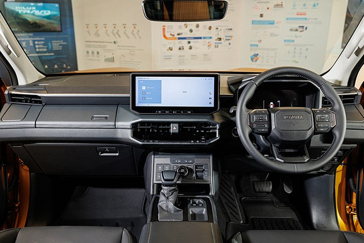 Bên trong, nội thất Hilux 2026 mang thiết kế hiện đại tương tự dòng Land Cruiser, nổi bật với bảng táp-lô trải ngang và cụm màn hình kép 12,3 inch: một cho hệ thống giải trí trung tâm và một cho cụm đồng hồ kỹ thuật số trước vô-lăng.