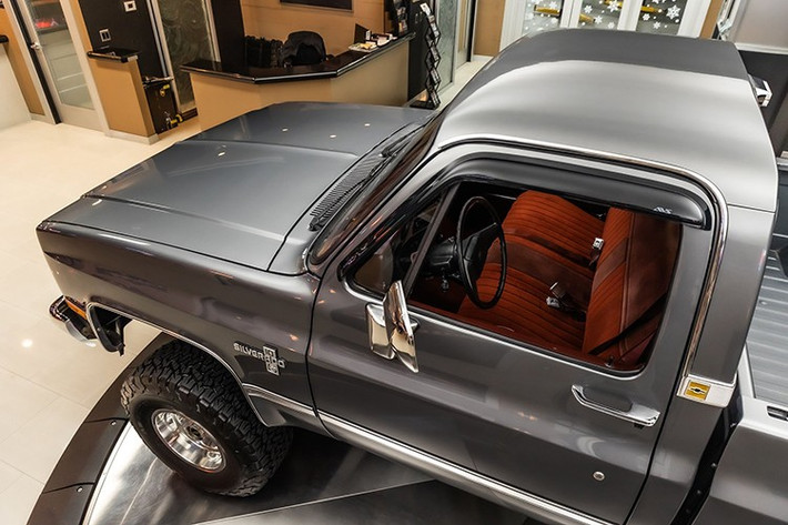 Nội thất xe được thiết kế riêng với khu vực ghế băng bọc da lộn màu đỏ hai tông màu có dây đai an toàn, ton sur ton với thảm sàn và trần xe màu đỏ.