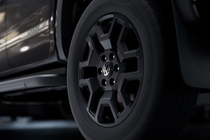 Volkswagen Amarok Dark Label 2026 sở hữu bộ mâm 20 inch màu đen mờ, dòng chữ đặc biệt, lưới tản nhiệt điểm xuyết màu đen và lớp bảo vệ gầm xe. Logo V6 được trang trí nổi bật, hé lộ động cơ nằm dưới nắp capo.