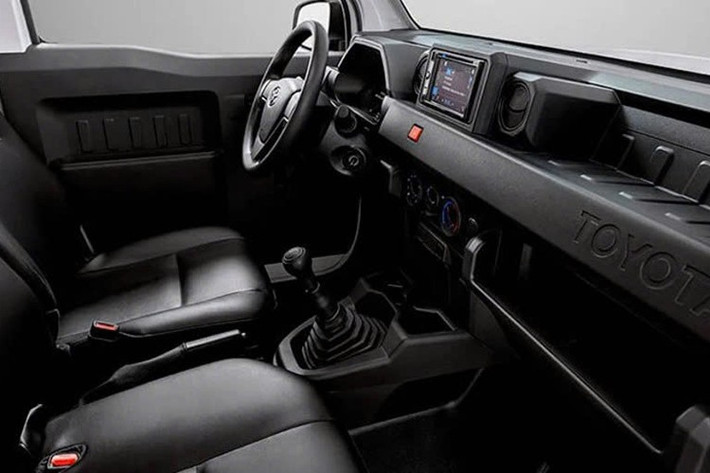 Bên trong, cabin xe bám sát một công thức đơn giản: bọc ghế đen với điểm nhấn màu cam, không có màn hình thông tin giải trí và các tính năng thực dụng cơ bản. Chúng gồm gương và cửa sổ chỉnh điện, ghế chỉnh tay, điều hòa, 1 cặp loa, cổng USB Type-C và thậm chí cả một tấm che nắng.