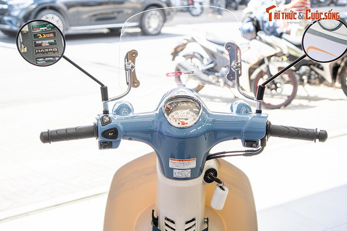 Điểm nhấn ở đầu xe là cụm đồng hồ analog tạo hình giọt nước giống với những mẫu Honda Super Cub 50cc cổ điển. Phiên bản cuối cùng của mẫu xe số huyền thoại thương hiệu Honda tiếp tục duy trì các trang bị ở mức cơ bản tại khu vực ghi-đông. Gương chiếu hậu dạng tròn cổ điển.