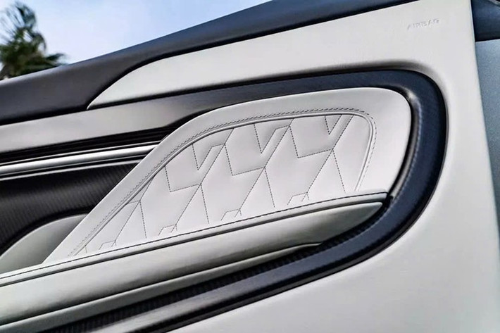 Cảm hứng hàng hải tiếp tục lan tỏa bên trong cabin, với nội thất phản ánh sự thanh bình và sang trọng của một salon du thuyền. Những chi tiết đáng chú ý bao gồm bọc da Glacier White, hoàn thiện với đường chần hình chữ V trải dài trên cửa và tay vịn trung tâm, đường khâu tinh xảo lấy cảm hứng từ những con sóng mũi tàu tạo thành khi chạy nhanh, cùng viền sợi carbon màu xanh lam satin và bóng khắp cabin.