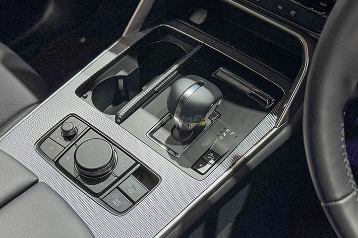 Ghế ngồi trên xe được bọc da màu đen, đục lỗ thông hơi và thêu chỉ màu vàng đồng. Xe có ghế trước chỉnh điện, ghế lái có nhớ vị trí nhưng không còn tính năng làm mát như bản cao cấp. Hàng ghế sau trang bị cửa gió riêng, cổng sạc USB, tựa tay trung tâm và có thể ngả hai nấc, đây là cải tiến đáng giá so với CX-5.