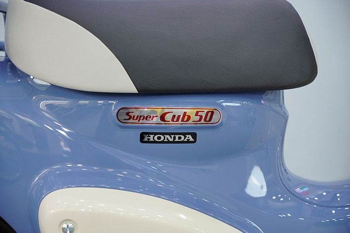 Thân xe được điểm xuyết bởi các chi tiết sơn bạc và mạ chrome, làm nổi bật phong cách cổ điển huyền thoại Honda Cub đã có từ hàng chục năm qua.