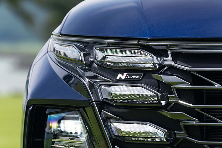 Phiên bản Tucson N Line sở hữu loạt thay đổi đáng chú ý về ngoại thất nhằm tạo nên phong cách cá tính, thể thao hơn so với bản tiêu chuẩn. Điểm nổi bật nằm ở lưới tản nhiệt thiết kế theo phong cách Parametric Jewel Hidden Lights đi kèm cản trước tái thiết kế mạnh mẽ. Logo N Line được đặt tinh tế trong dải đèn LED định vị ban ngày.