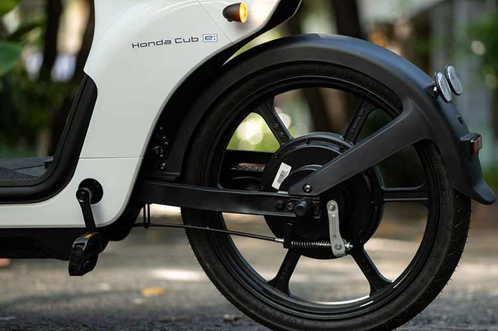 Trong khi đó, đèn xi nhan được đặt ở hai bên, gần tay lái. Đồng hồ công tơ mét dạng kỹ thuật số, hiển thị các thông số cơ bản như dung lượng pin, số ODO và tốc độ. Ngoài ra, Honda Cub E còn được tích hợp tính năng kết nối với điện thoại thông minh, từ đó người dùng có thể theo dõi các thông tin về dung lượng pin, quãng đường hay định vị GPS.