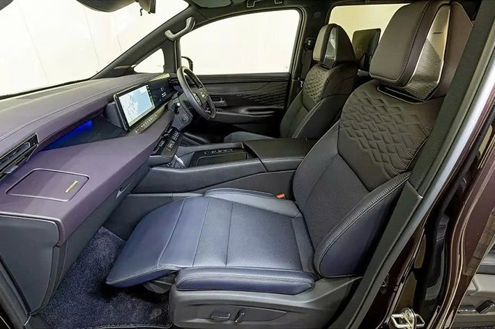 Bên dưới cửa gió của Nissan Elgrand 2026 là hàng nút điều khiển điều hòa. Dưới nữa là cụm nút chọn số, chế độ lái thuần điện, chế độ vận hành một bàn đạp e-Pedal và hai khay sạc không dây.