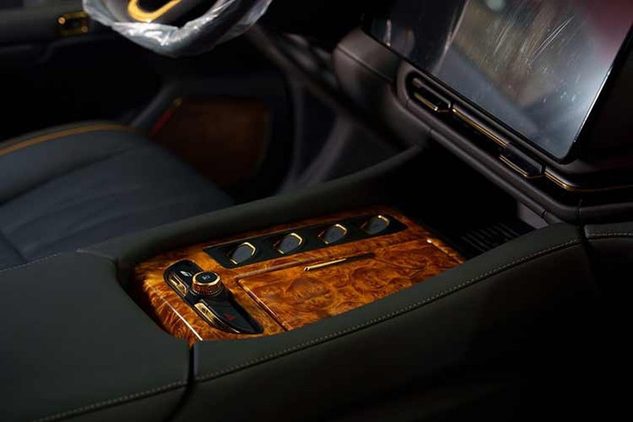 Bên trong VinFast Lạc Hồng 900 LX là nội thất được ốp, bọc và mạ bởi các loại vật liệu cao cấp như gỗ quý Golden Nanmu, da Nappa hay vàng thật. Toàn bộ chi tiết mạ vàng trong và ngoài xe đều được làm hoàn toàn thủ công. Ngoài ra, xe còn có những trang bị đáng chú ý khác như vô lăng bọc da với logo chữ V ở giữa...