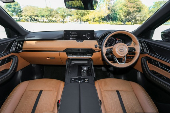 Khoang nội thất của CX-80 được bố trí 6 chỗ ngồi với hàng ghế giữa là cặp ghế thương gia tích hợp sưởi, thông gió và ngả điện, có bệ tì tay riêng. Ghế lái và ghế phụ phía trước đều chỉnh điện 10 hướng, ghế lái có thêm chức năng nhớ vị trí và cá nhân hóa người dùng.