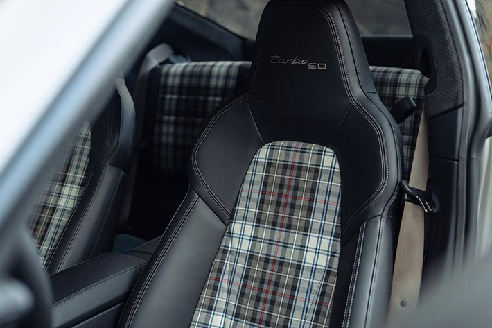 Bảng táp-lô phía hành khách được khắc số thứ tự sản xuất trong tổng 1.974 xe, kèm huy hiệu “Turbo 50”. Xe còn được trang bị gói Sport Chrono, bao gồm các chức năng như Launch Control, đồng hồ analogue đo vòng đua, cần số thiết kế lấy cảm hứng từ xe đua, và chế độ lái tích hợp vô lăng.