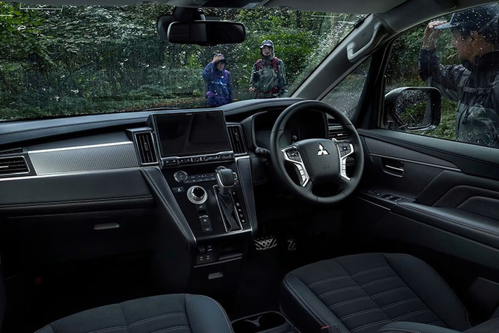 Bên trong khoang lái, Mitsubishi Delica D:5 2026 có nâng cấp công nghệ đáng chú ý nhất là bảng đồng hồ kỹ thuật số 8 inch mới. Trang bị này kết hợp với màn hình giải trí trung tâm 10,1 inch như cũ và vẫn đặt trên bệ tì tay trung tâm nghiêng. Bố cục nội thất của xe cũng không thay đổi, vẫn đi kèm 3 hàng ghế và chở tối đa 8 người.