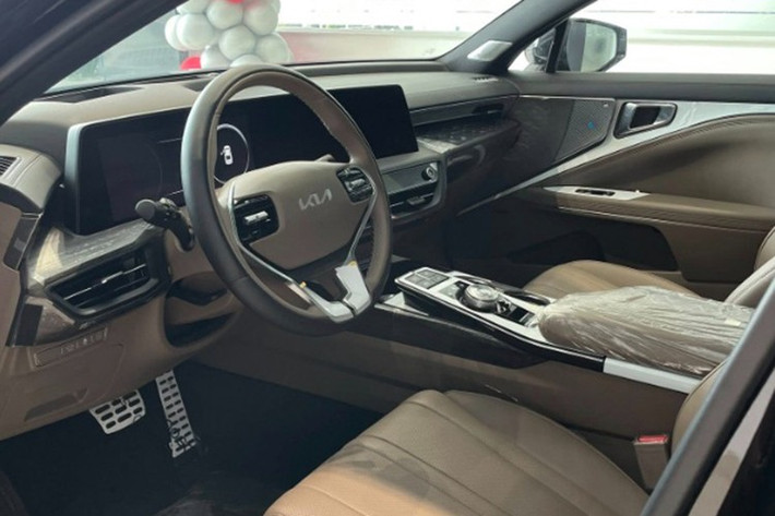 Bên trong Kia K8 là không gian nội thất khá rộng rãi và sang trọng. Tại đây, xe được trang bị mặt táp-lô 2 tầng, vô lăng 3 chấu, màn hình cảm ứng chỉnh điều hòa và nút bấm chuyển số. Đặc biệt, xe còn sở hữu cụm màn hình cong trên mặt táp-lô, tích hợp bảng đồng hồ kỹ thuật số và màn hình thông tin giải trí cùng có kích thước 12 inch.