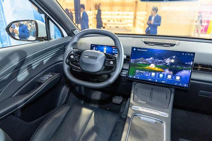 Bên trong nội thất của Omoda C7 SHS Flagship khá tối giản. Toàn bộ các chức năng được tích hợp vào trong màn hình trung tâm 15,6 inch, bao gồm kết nối Apple CarPlay/Android Auto không dây. Một số tính năng có nút vật lý hoặc nút phím tắt nhanh như âm lượng, chuyển chế độ lái,... được đặt ở khu vực bệ trung tâm, cạnh với khay sạc không dây.