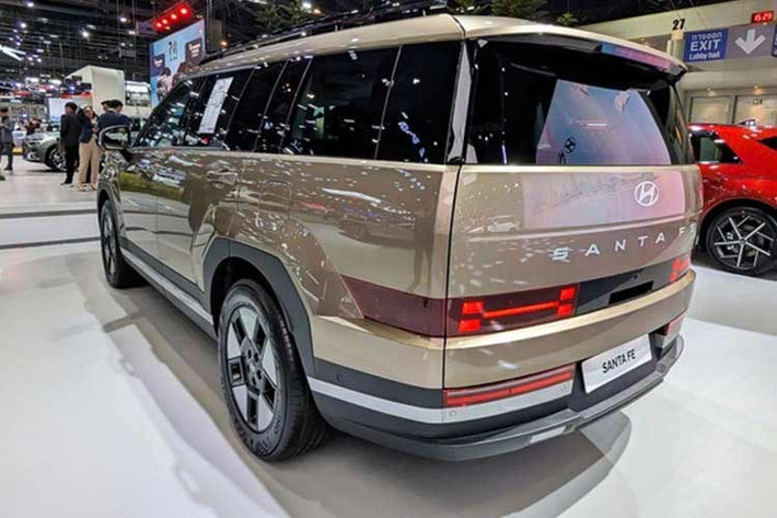 Ngoại hình SantaFe Hybrid 2026 tương tự bản động cơ đốt trong với tạo hình vuông vức, bề thế. Ngay từ phiên bản Exclusive tiêu chuẩn, xe đã sở hữu danh sách trang bị khá đầy đủ với đèn LED chạy ban ngày, đèn hậu LED, đèn chào mừng, kính chắn gió hai lớp và mâm 18 inch đi kèm cốp điện rảnh tay.