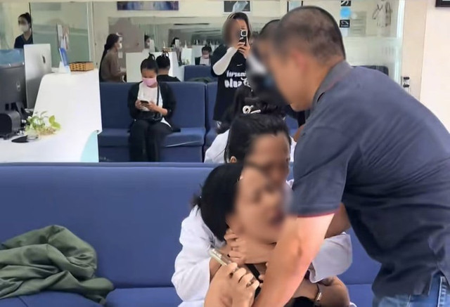 Bà C dùng hai tay giữ chặt cổ khách hàng. Ảnh cắt từ clip/Nguồn Danviet.vn