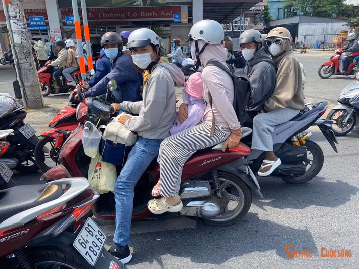 Trẻ em theo cha mẹ trở lại thành phố cũng mệt mỏi, bơ phờ dưới thời tiết nắng nóng oi bức và sau chặng đường dài.