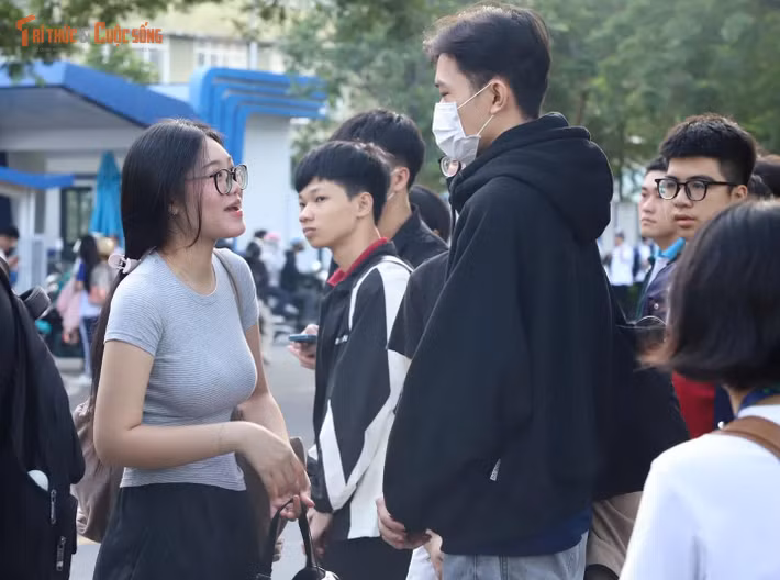 Trong lúc chờ xe buýt, nhiều sinh viên trò chuyện với bạn học về các nội dung học tập trên lớp.
