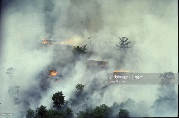 Ngôi làng ngập chìm trong lửa khói sau mưa bom napalm, 1966.