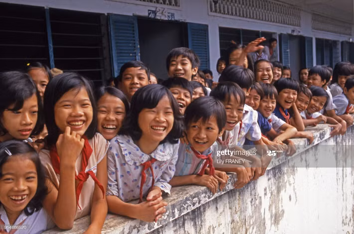 Các em học sinh ở một ngôi trường tại Hà Nội cười tươi như hoa khi được nữ phóng viên Pháp chụp ảnh.