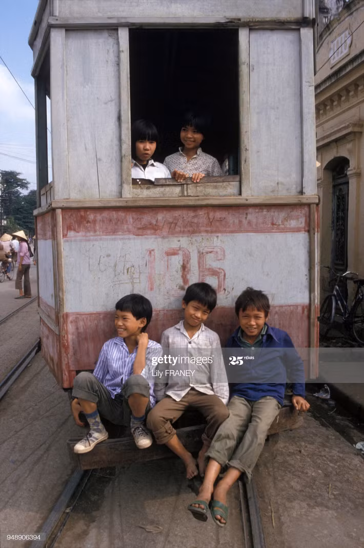 Ba cậu bé phía sau toa tàu điện.