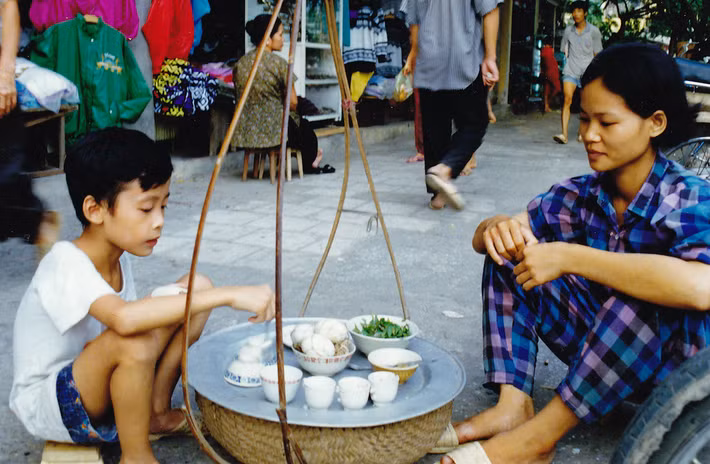 Em bé được phục vụ tại gánh hàng trứng vịt lộn, một món ăn được báo chí quốc tế coi là "kinh dị" nhưng rất phổ biến ở Hà Nội. Ảnh: Bo Kage Carlson / Flickr.