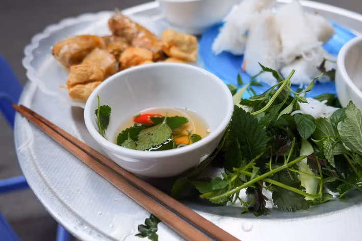 "Món ăn đường phố ngon nhất của chúng tôi ở Hà Nội là đĩa đậu phụ rán, bún, rau thơm và nem", nữ du khách chụp bức ảnh này nhận xét. Ảnh: Laura Jacobsen / Flickr.