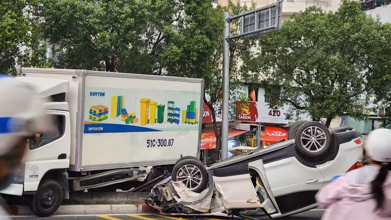 Va chạm với xe tải, ô tô 5 chỗ lật ngửa trên đường Võ Văn Kiệt kẹt xe kéo dài