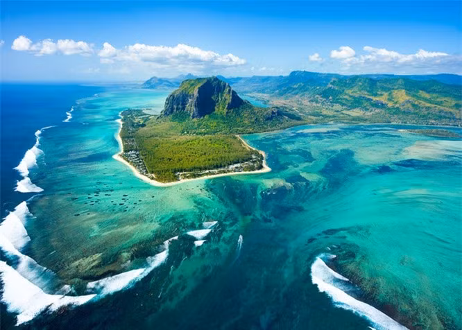 2. Ảo giác “thác nước dưới đáy biển” tại đảo Mauritius: Đảo Mauritius là một nơi tuyệt đẹp và độc đáo. Được mệnh danh là một thiên đường nhiệt đới, thiên nhiên nơi đây cũng vô cùng kì vĩ và tạo ra một ảo ảnh đáng kinh ngạc. Khi nhìn từ trên cao xuống, dòng chảy của cát và phù sa tạo ra một cảnh quan ấn tượng về một thác nước dưới đáy biển. 